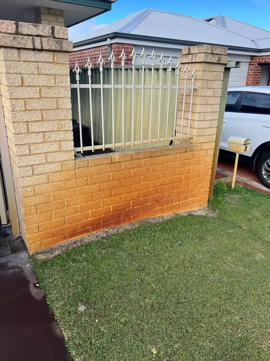 Brick wall stained orange by bore water before treatment